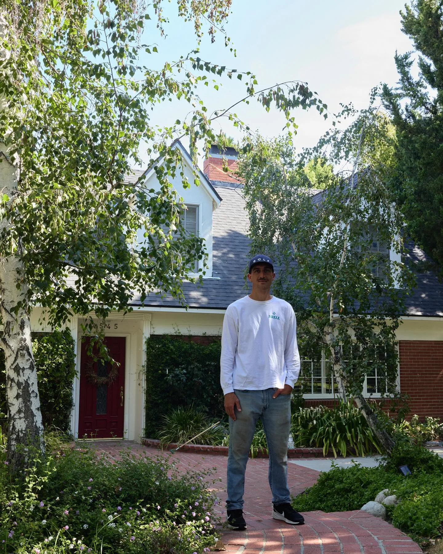 Asa Wolfe standing in front of a completed Swell Roofing project