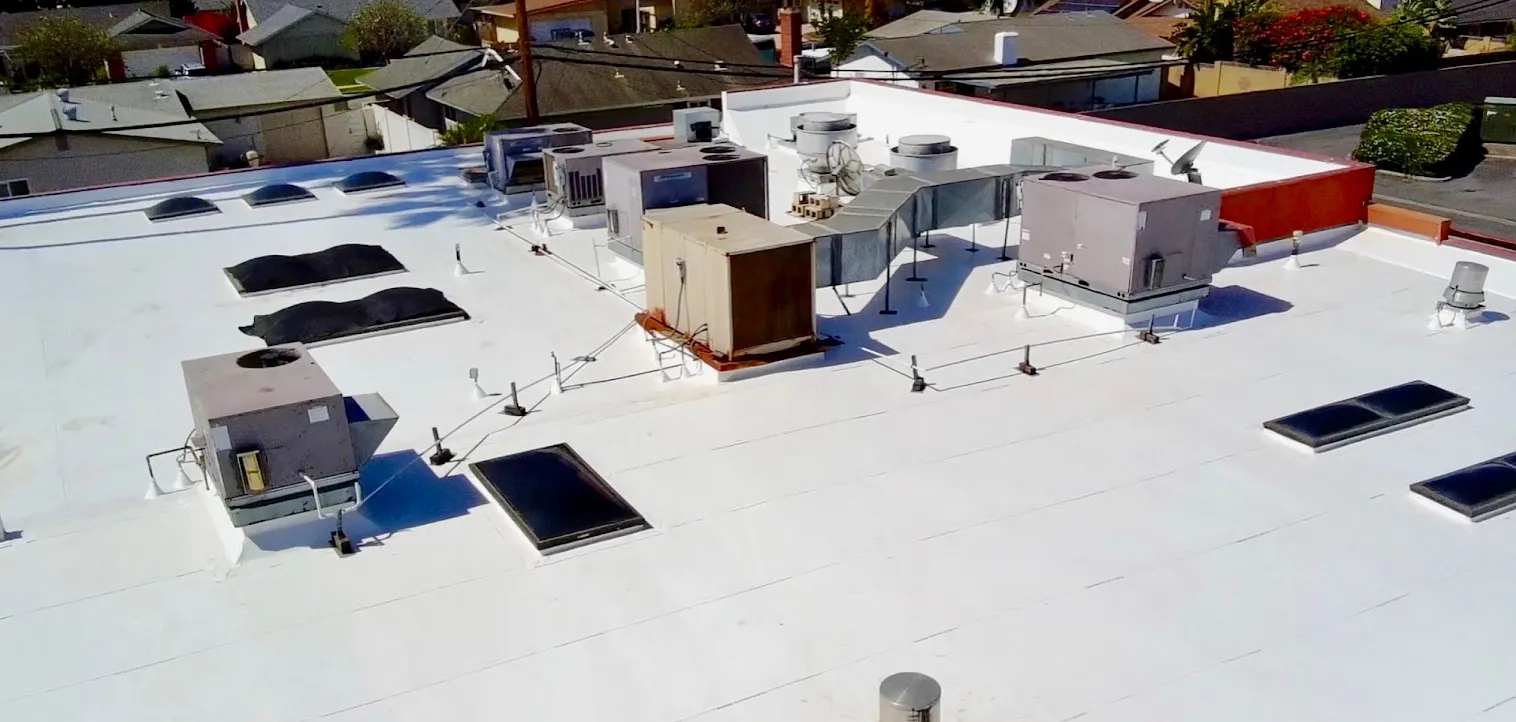 The same commercial flat roof from above after a bright white reflective coating