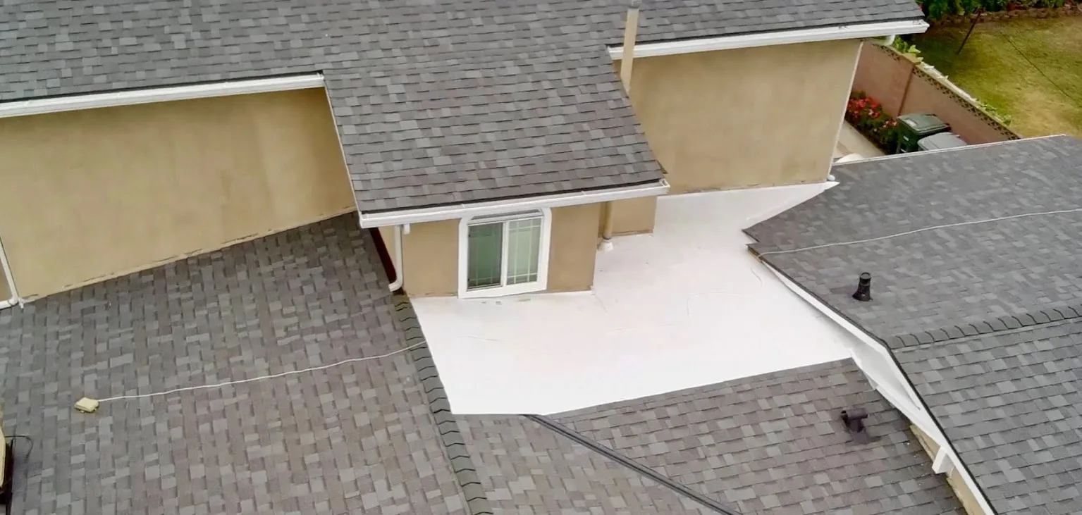 The same roof from above with new gray shingles and a bright white flat section