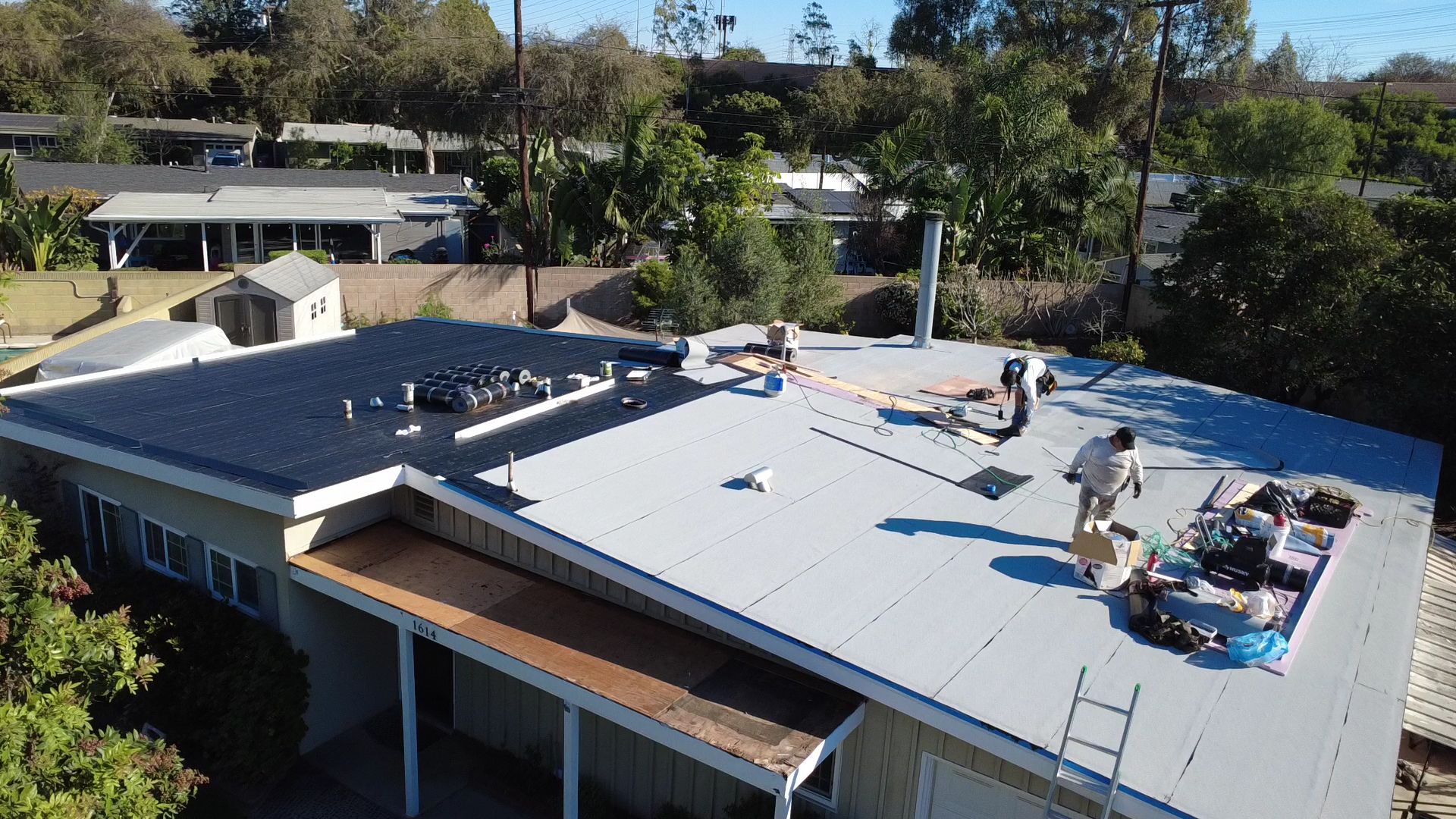 Aerial view of a Swell Roofing crew working across a commercial flat roof