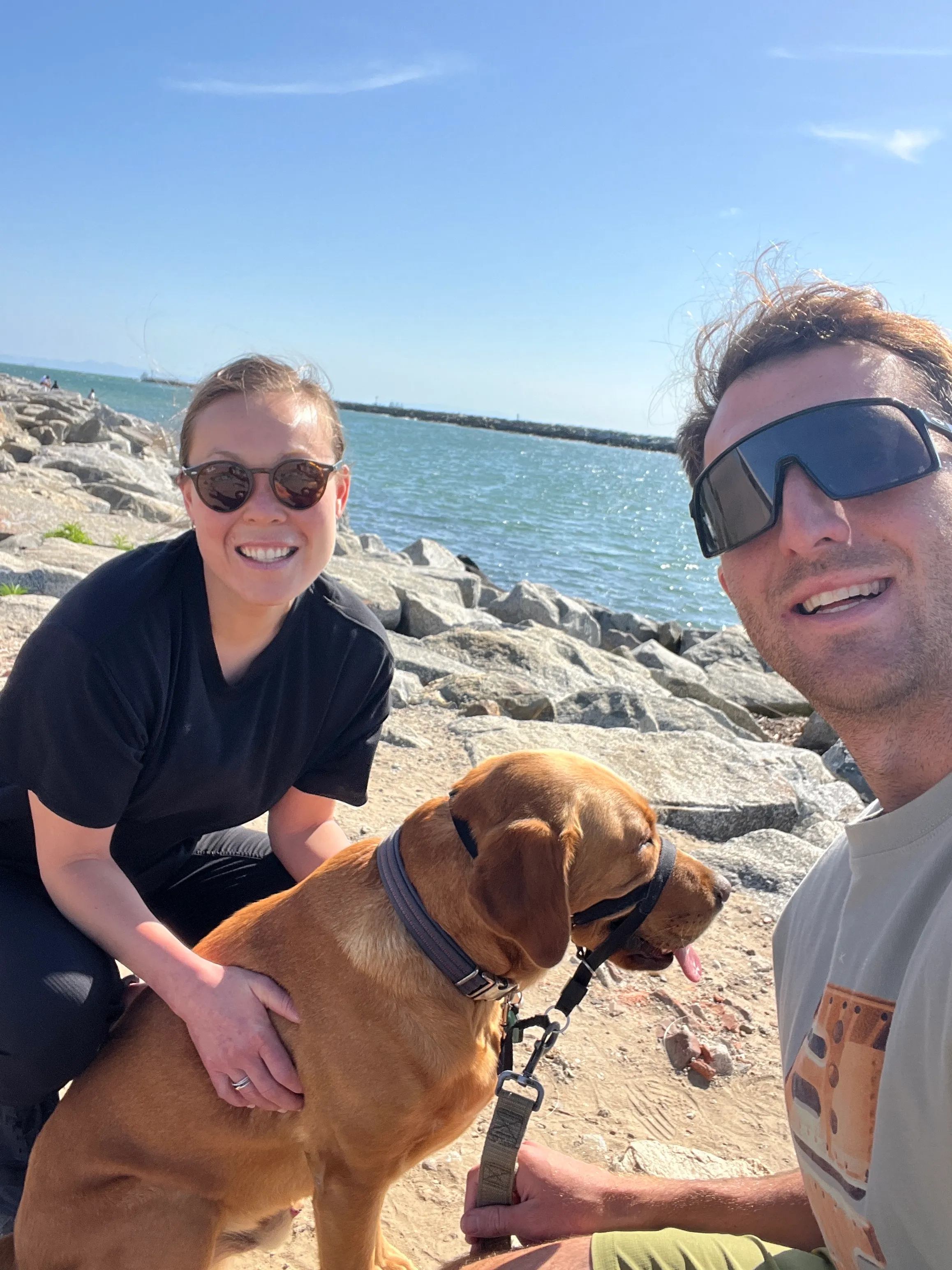 Asa Wolfe with his wife and Labrador retriever by the water