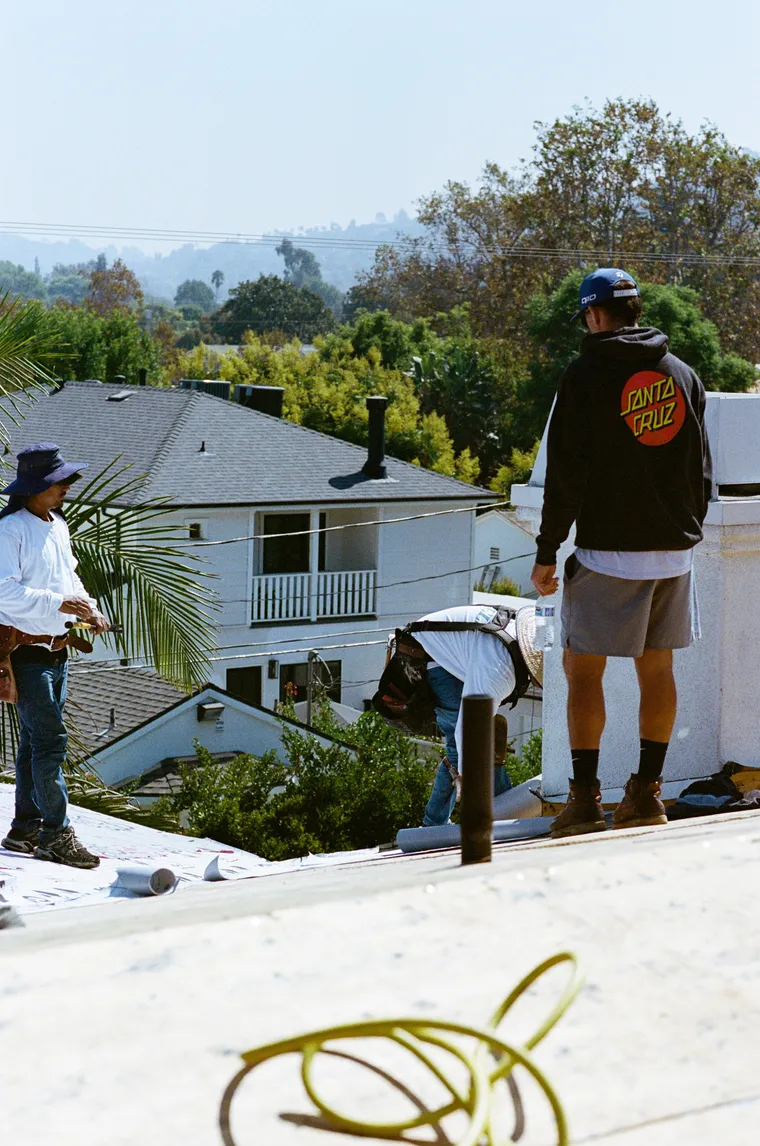 Roofing crew working together above a residential neighborhood