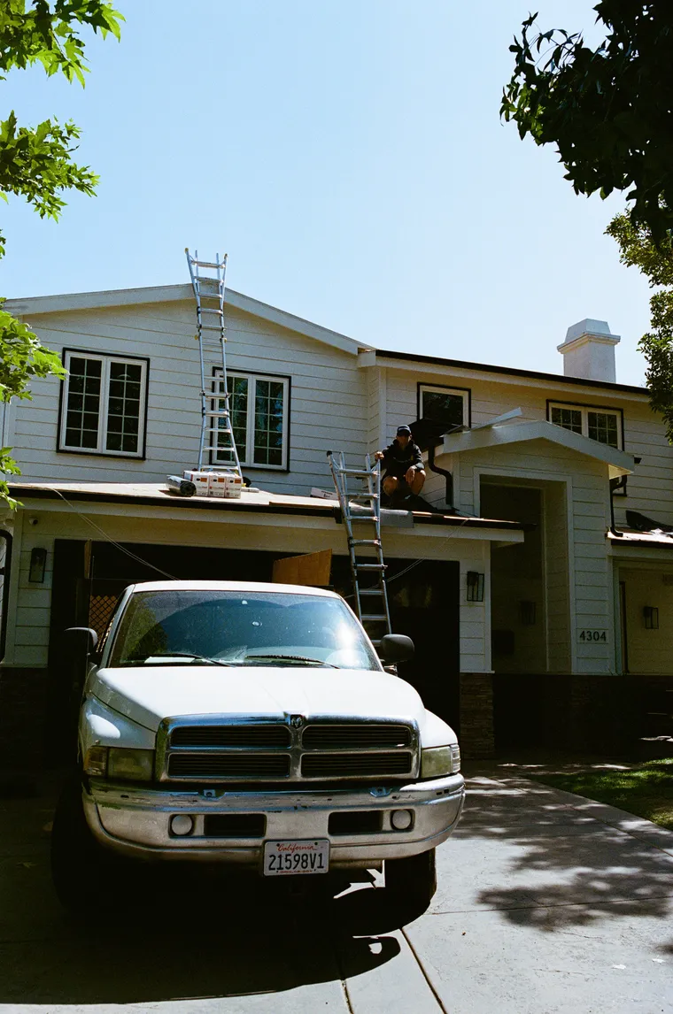 Roofing ladders staged carefully at a white house