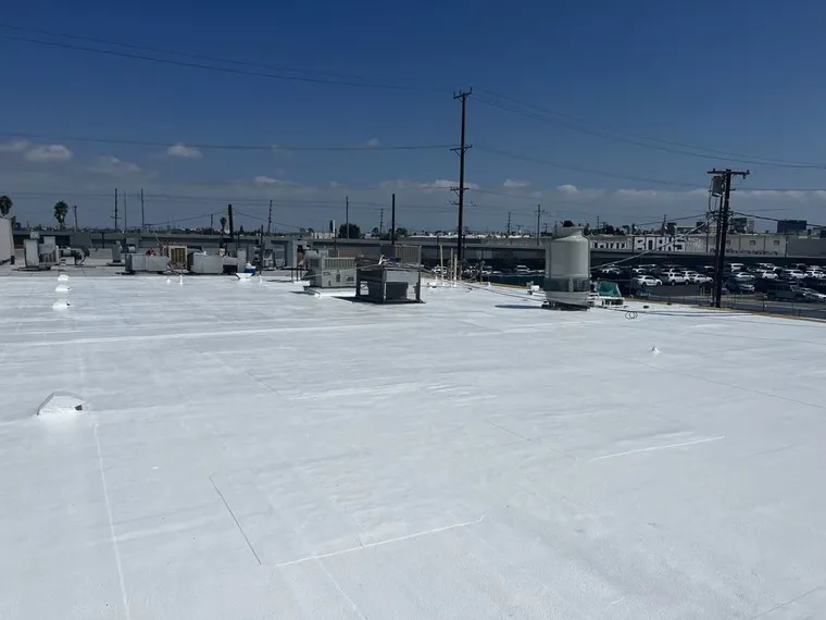 Finished bright white commercial flat roof with rooftop equipment