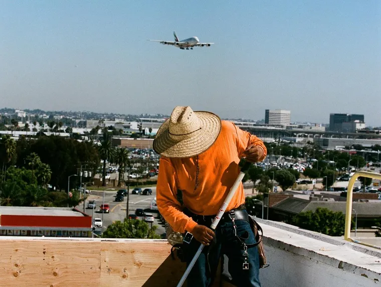 Worker detailing membrane around a pipe penetration