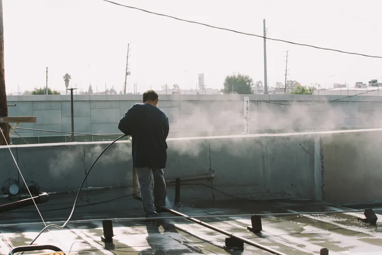 Wide view of pressure washing across a flat roof