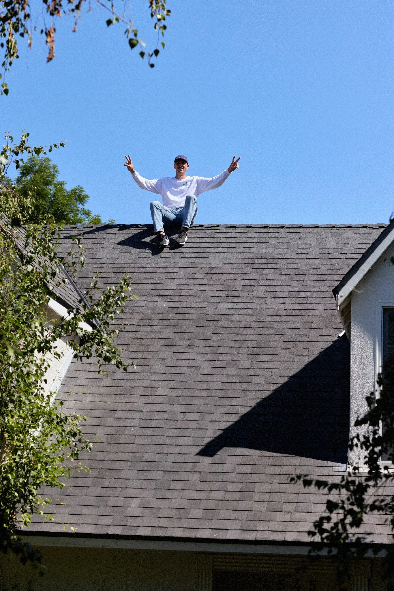 Swell roofer celebrating on a finished shingle roof