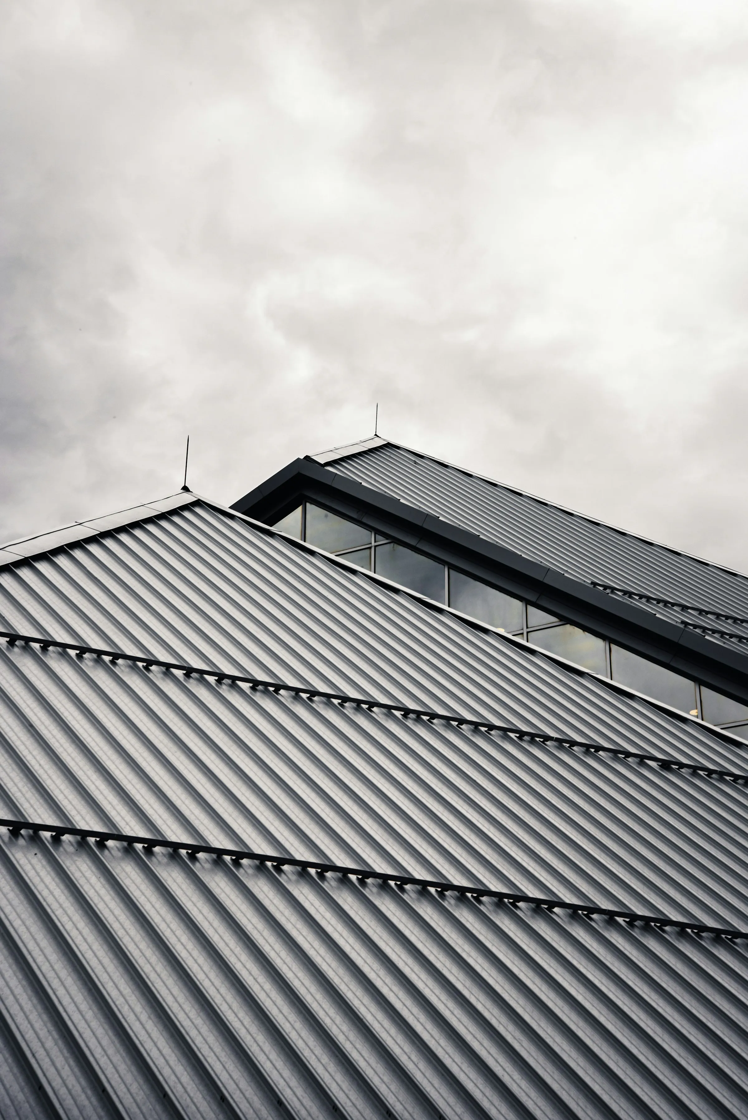 Standing-seam metal roof panels meeting at a ridge