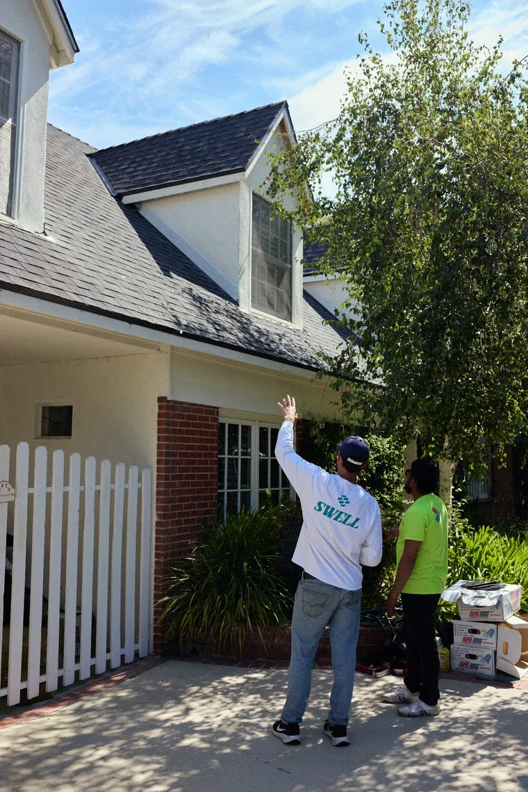 Swell Roofing crew walking up a driveway with supplies