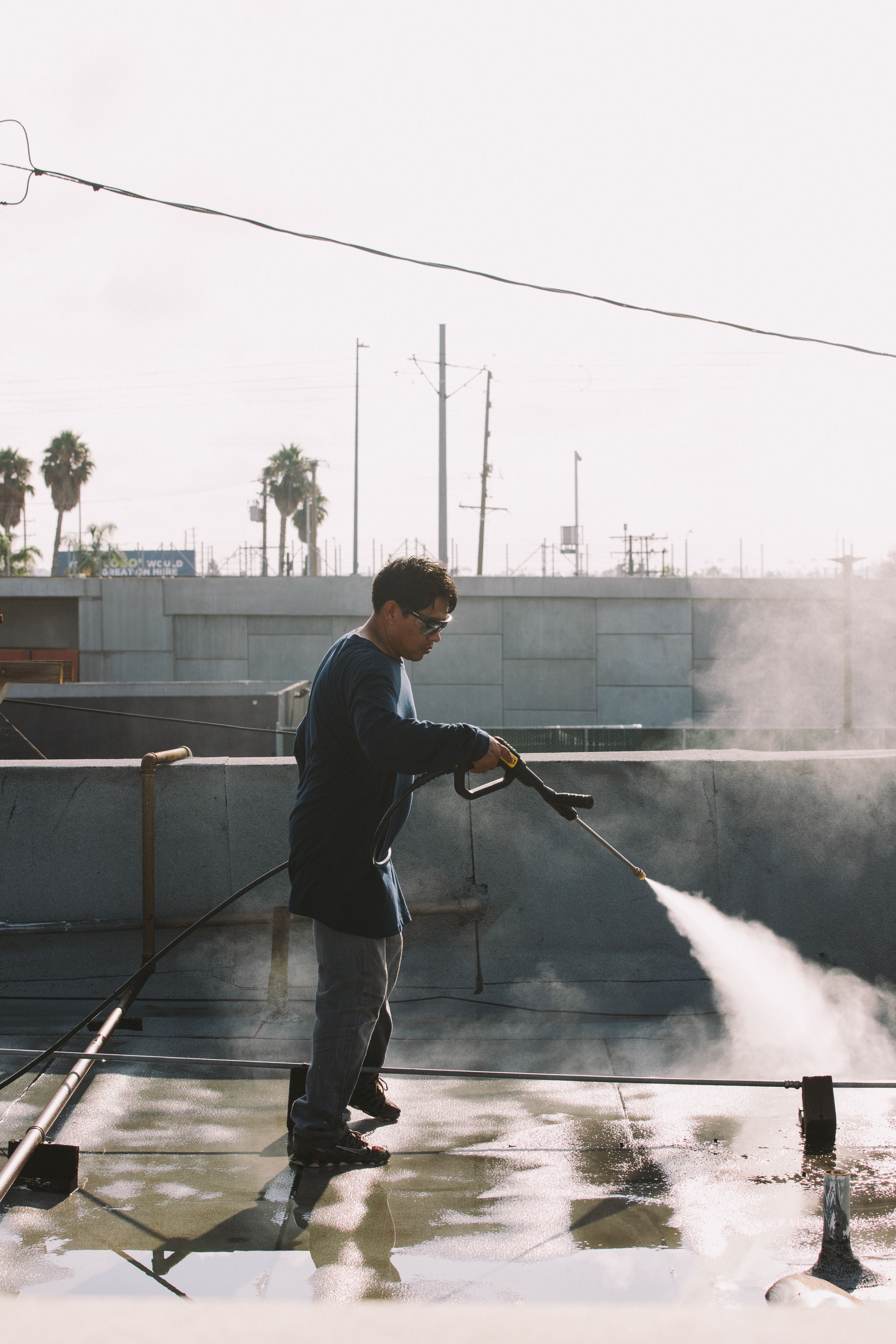 Swell roofer pressure washing a commercial flat roof